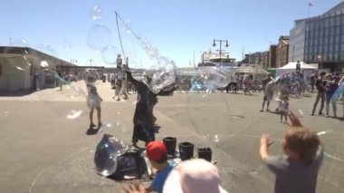 Aker Brygge, Oslo Promenade sabun köpüğü ile oynayan çocuklar.