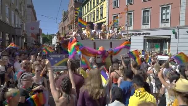 Pride Parade v norském Oslo. Hodně lidí maškarní s duhové vlajky tančit, zpívat a smát se na ulici. — Stock video