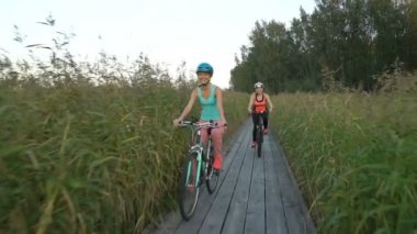 İki kadın arasında sazlık ahşap bir ekolojik iz bisiklet binmek