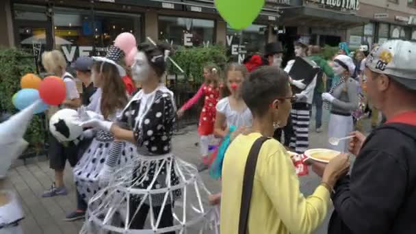 Children and adults in theater costumes go through the streets of the city. — Stock Video