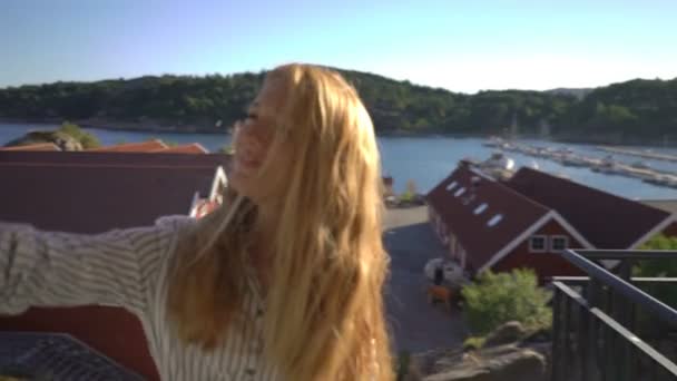 Unga rödhårig kvinna tar bilden av sig själv på terrassen vid kusten i norra Europa — Stockvideo