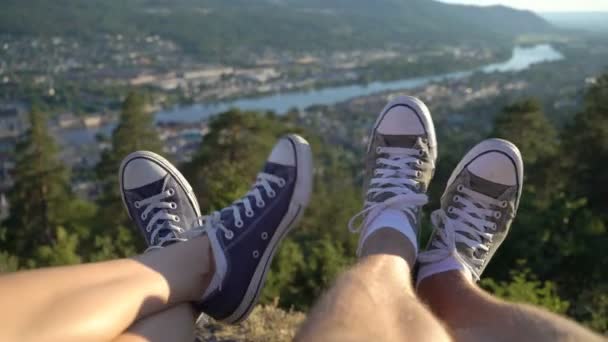 Pies si pareja joven en zapatillas de deporte en el fondo del valle con el río — Vídeo de stock