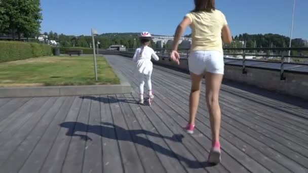 Dos niñas montando patada scooter al aire libre . — Vídeos de Stock