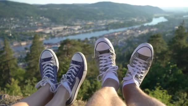 Pies si pareja joven en zapatillas de deporte en el fondo del valle con el río — Vídeos de Stock