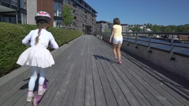 Dwie małe dziewczynki konna Kick skuter na zewnątrz. — Wideo stockowe