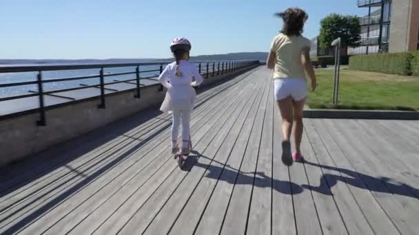 Dos niñas montando patada scooter al aire libre . — Vídeos de Stock