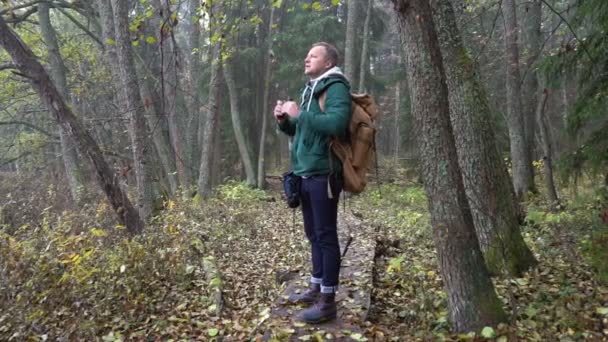 Человек средних лет на экологической природной тропе через осенний лес в природном парке — стоковое видео