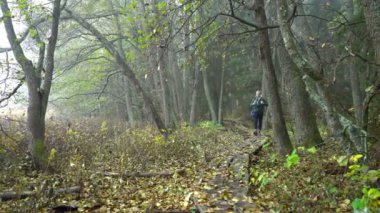 Orta yaşlı adam ile bir sonbahar ormanda doğal bir park ve ekolojik bir doğa iz üzerinde