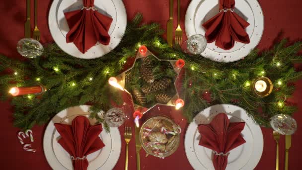 Fiestas navideñas mesa roja con velas y guirnalda . — Vídeos de Stock