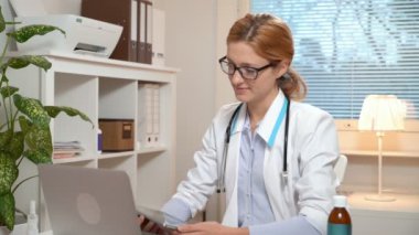 Tıp online. Genç kadın doktor görüntülü sohbet kullanarak bir hasta danışır.