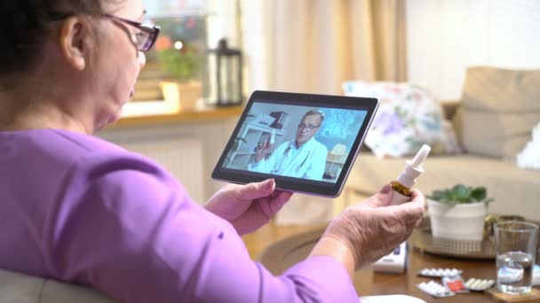 Medicine online. Elderly woman consulting with her doctor using video chat at home — Stock Video