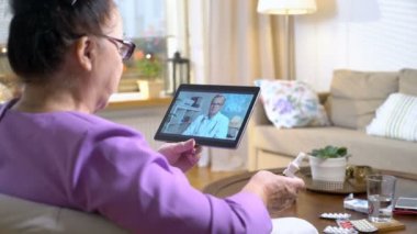 Tıp online. Yaşlı kadın evde video sohbet etmek kullanma onun doktoru ile danışmanlık