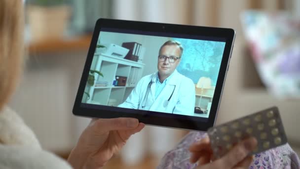 Лекарство онлайн. Молодая женщина консультируется со своим врачом, используя видео-чат дома — стоковое видео