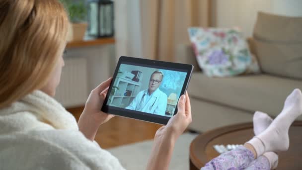 Médecine en ligne. Jeune femme consultant son médecin en utilisant le chat vidéo à la maison — Video