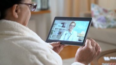 Tıp online. Yaşlı kadın evde video sohbet etmek kullanma onun doktoru ile danışmanlık