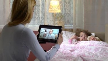 Anne küçük hasta kızı olan alır bir doktorlar konsültasyon evde video sohbet etmek kullanma.