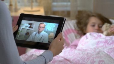 Anne küçük hasta kızı olan alır bir doktorlar konsültasyon evde video sohbet etmek kullanma.