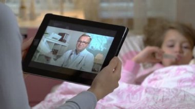 Anne küçük hasta kızı olan alır bir doktorlar konsültasyon evde video sohbet etmek kullanma.