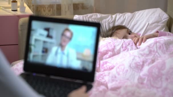 Mãe com um pouco de filha doente recebe uma consulta de médicos usando vídeo chat em casa . — Vídeo de Stock