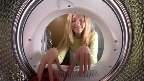 Vicces kis lány anyja és apja a ruhákat, hogy mosógéppel rakodási. — Stock videók