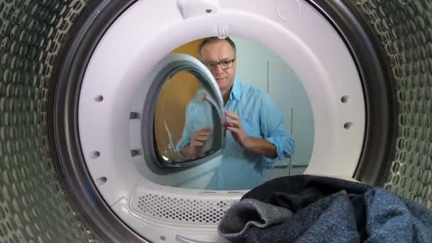 Man loading the the clothes to washing machine. — Stock Video