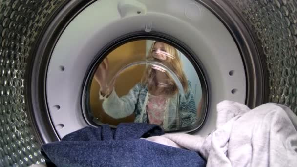 Young woman loading the clothes to washing machine. — Stock Video