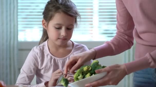 Meisje eten broccoli en spinazie. — Stockvideo
