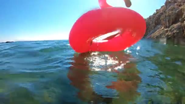 Jovem mulher esbelta gosta do mar e do sol deitado em um Flamingo rosa inflável — Vídeo de Stock