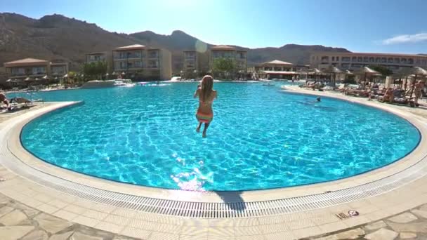Joven mujer delgada saltando a la piscina y nadando bajo el agua — Vídeos de Stock