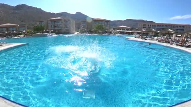 Junge schlanke Frau springt in den Pool und schwimmt unter Wasser — Stockvideo