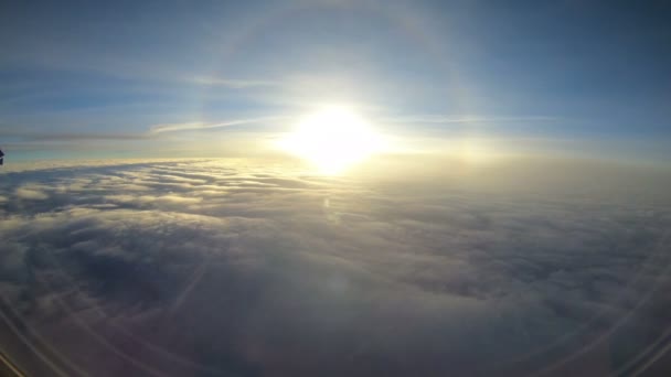 Vista del atardecer sobre las nubes desde la ventana del avión — Vídeo de stock