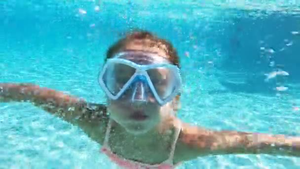 Menina vestindo máscara de snorkel nadando debaixo d 'água na piscina . — Vídeo de Stock