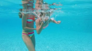 Küçük kız havuzda su altında.