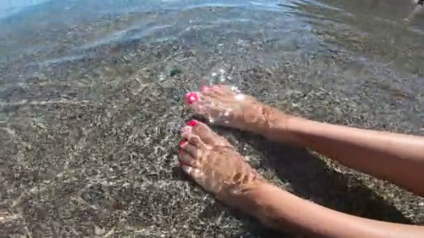 Mujeres pies en las olas del mar en la playa. Vista superior de la parte del cuerpo. Pedicura dedos de los pies — Vídeo de stock