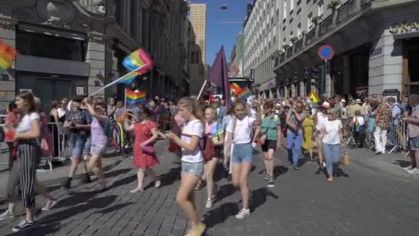 The Pride Parade in Oslo Norway. A lot of fancy-dress people with rainbow flags dance, sing and laugh in the street. — Stock Video