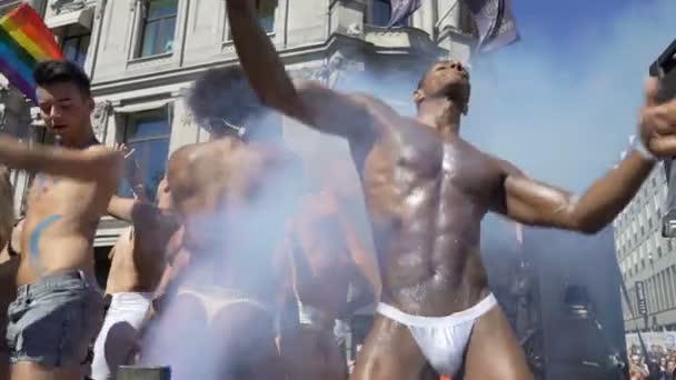 Pride Parade v norském Oslo. Napůl nahé sexy kluci tančí na pohybující se plošině. — Stock video