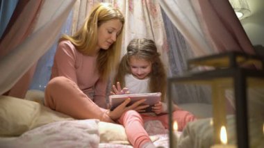 Genç anne ve kızı eğleniyor apps oynarken tablet kullanma