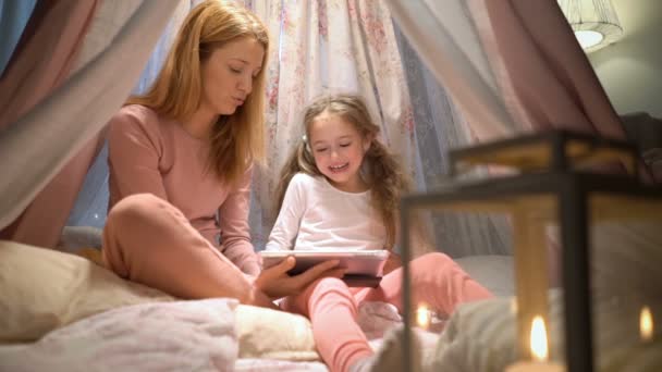 Jovem mãe e sua filha se divertindo usando aplicativos de jogo tablet — Vídeo de Stock