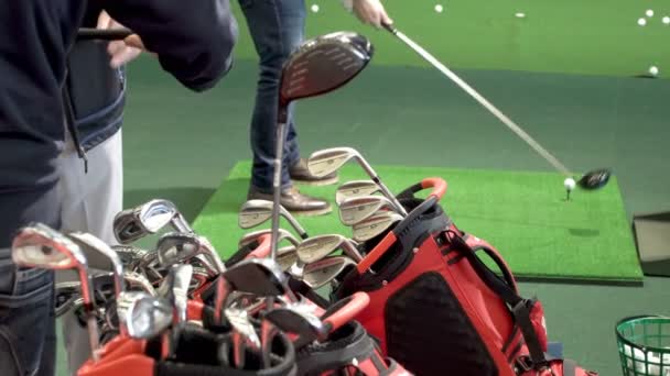 Покупці тестування різні гольф-клуби в гольф магазин. — стокове відео
