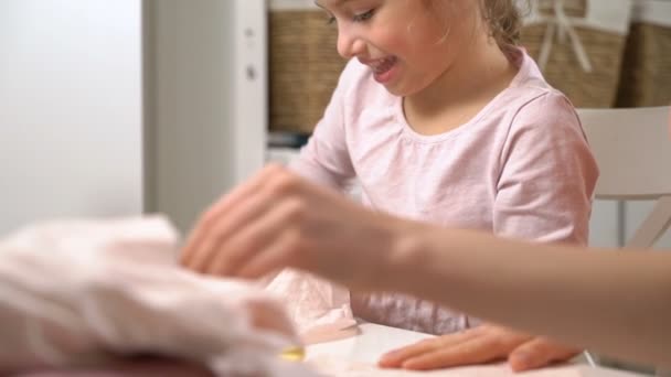 Mamá y su hijita hacen costuras juntas. Chica con tijeras corta el paño para bricolaje — Vídeos de Stock