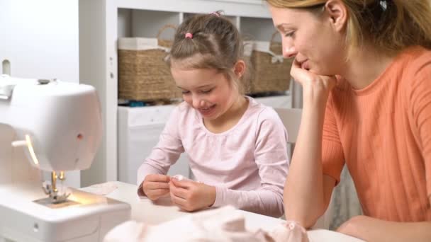 Mamá enseñando a su hijita a coser con aguja e hilo — Vídeos de Stock