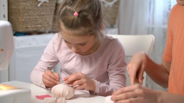 Moeder leert haar kleine dochter te naaien met behulp van naald en draad — Stockvideo
