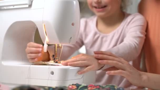 Mãe ensinando sua filhinha a costurar usando uma máquina de costura no berçário em casa — Vídeo de Stock