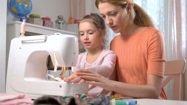Μαμά διδασκαλία μικρή κόρη της να ράψει χρησιμοποιώντας μια ραπτομηχανή στο παιδικό δωμάτιο στο σπίτι — Αρχείο Βίντεο