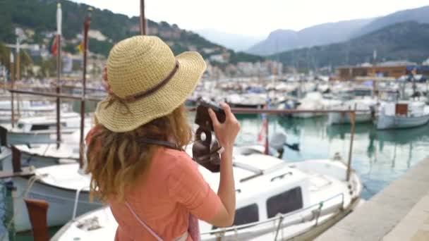 Portrait of young woman wearing straw hat smiling at the camera seacoast background. — Stock Video