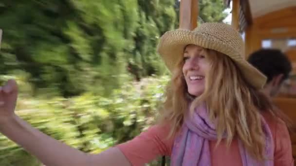 A young woman wearing straw hat enjoying traveling on an old tram — Stock Video
