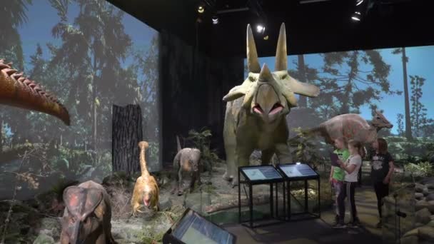 Kinder und Erwachsene sehen interaktive Modelle von Dinosauriern. — Stockvideo
