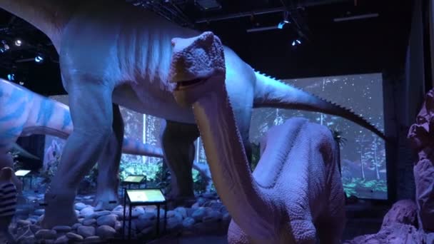 Enfants et adultes voient des modèles interactifs de dinosaures . — Video