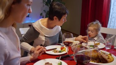 Mutlu aile bir ziyafet masasının etrafında toplanmış Noel hindisinin tadını çıkarıyorlardı. Noel ağacını, parıldayan ışıkları, birliktelik ve geleneğin ılık atmosferini evde kutluyorlardı..