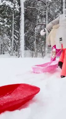 Middle age mother and teenage daughter bonding during winter holiday, walking with sleds in snowy day. Family values, joy, love and togetherness in outdoor fun.
